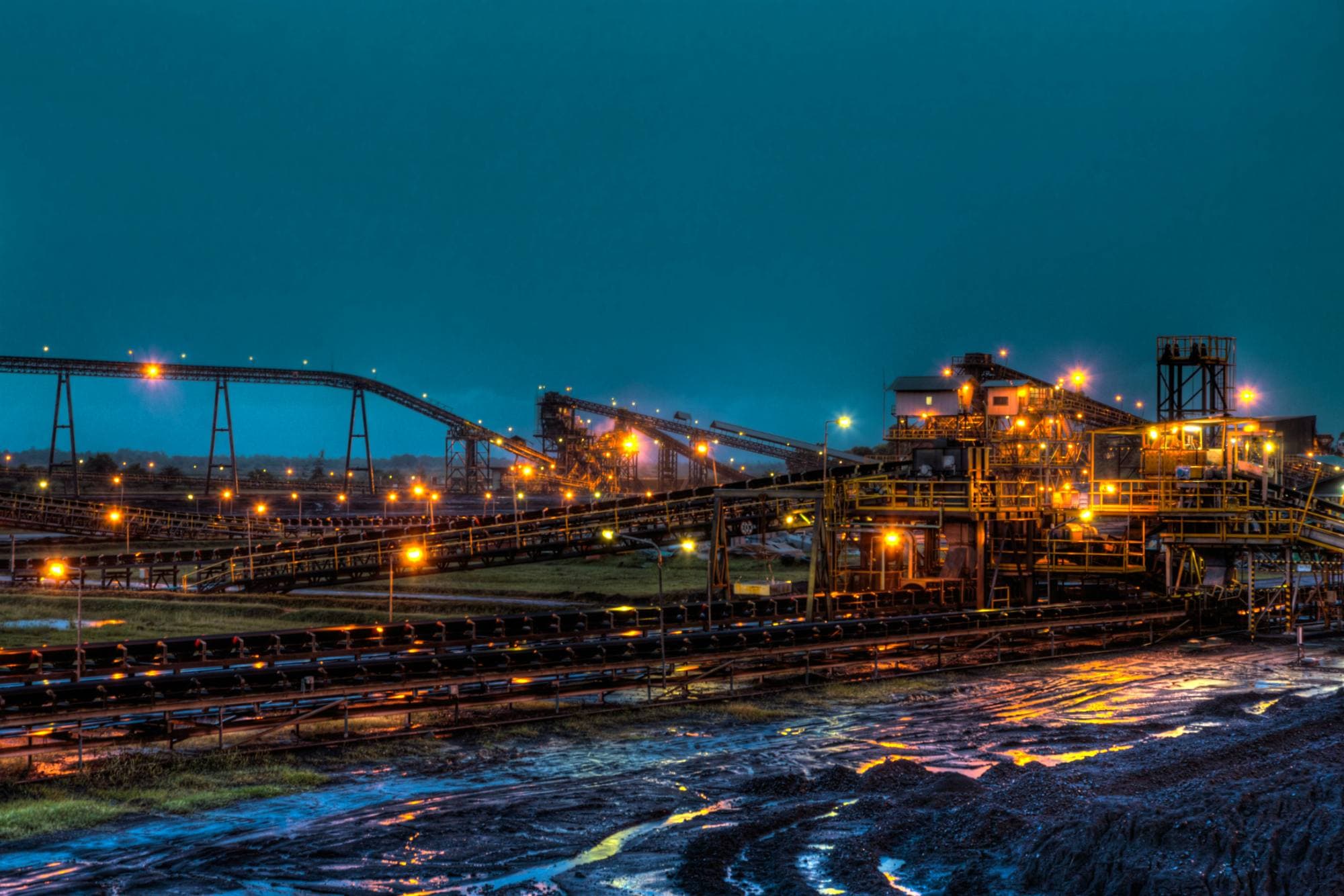 Ore processing plant and conveyors lit at dusk