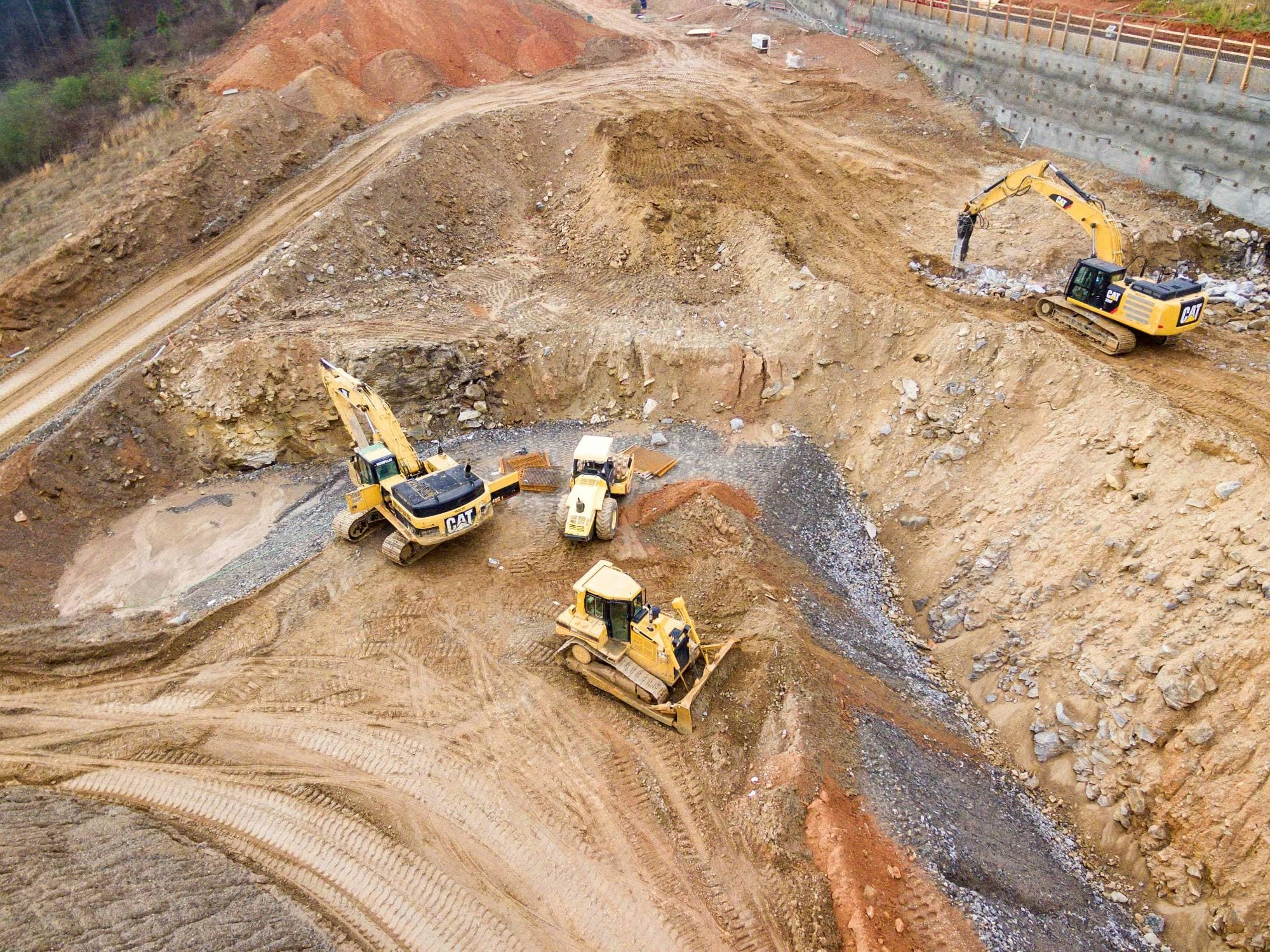 Aerial view of excavators and a dozer working a mine bench